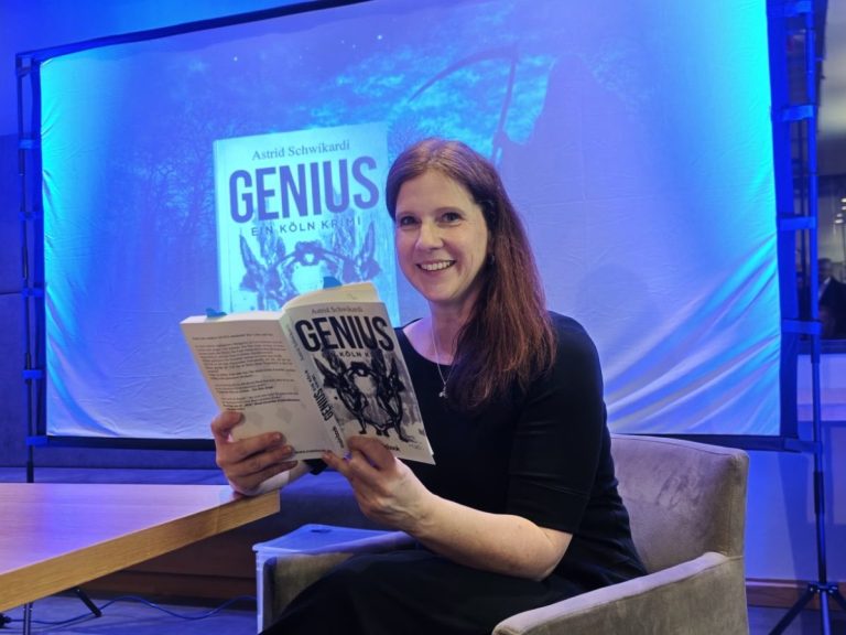 Frau mit langen Haaren liest ein Buch mit dem Titel "Genius" vor einem blauen Hintergrund.