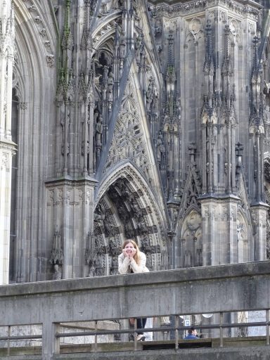 Frau posiert vor Architektur eines Doms in Köln