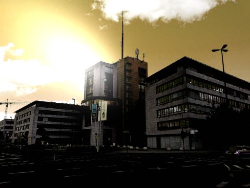 Städtisches Gebäude vor einem hellen, orangefarbenen Himmel.